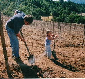 Eric and young Riley working in vineyard